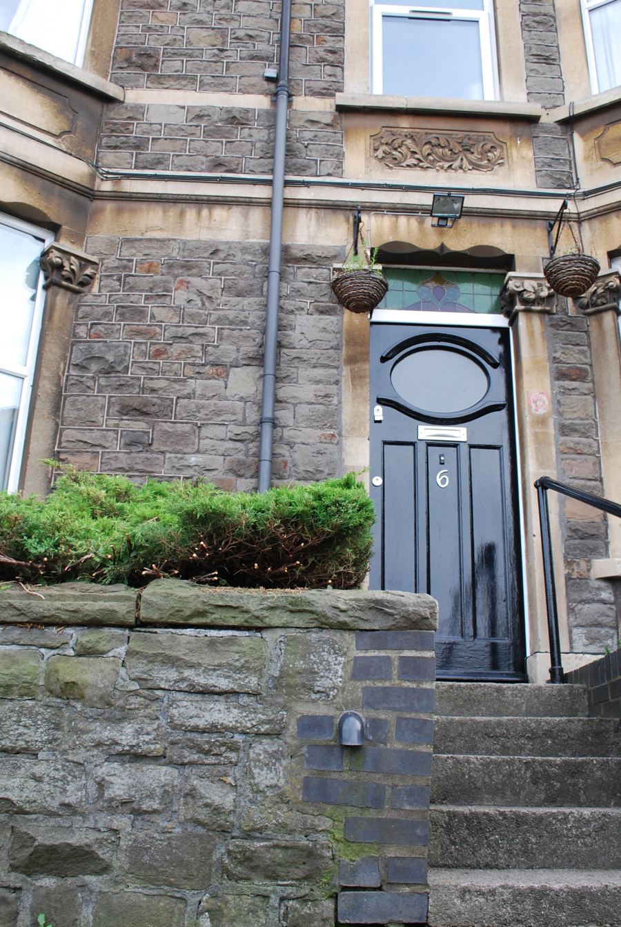The front steps and black door of number 6